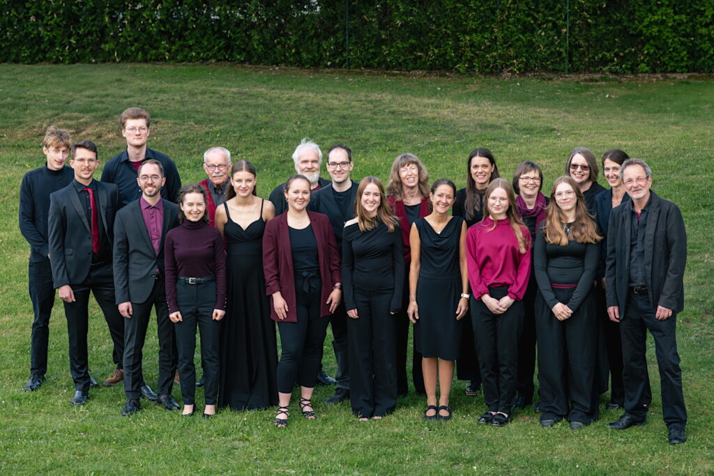 Das Neue Burgthanner Streichensemble steht in Konzertkleidung im Garten des Musikforums und lächelt in die Kamera